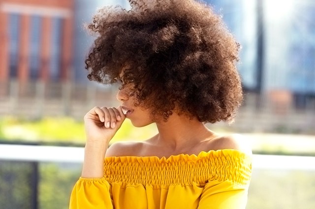 black woman with an afro in a yellow shirt
