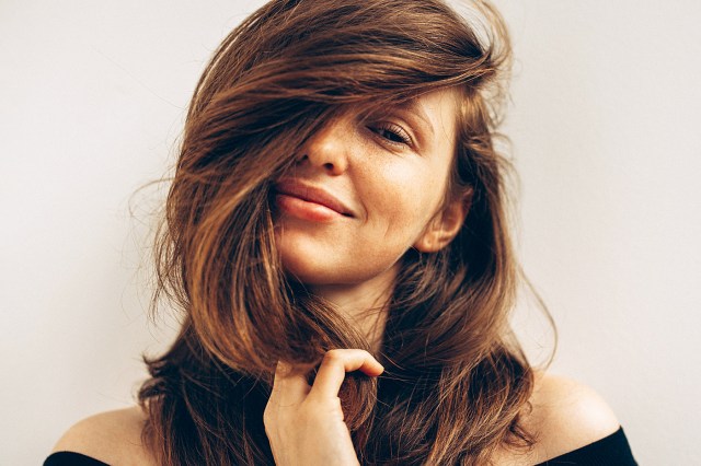woman with brown hair and a deep side part 