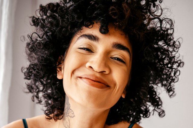 woman with curly hair smiling 