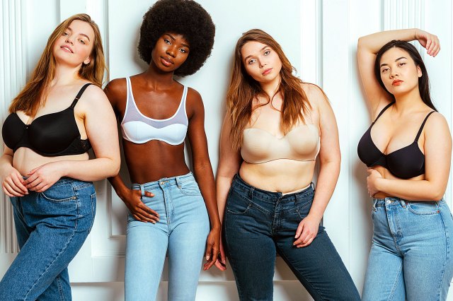 four women wearing bras and jeans