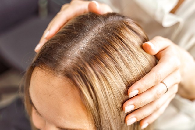 top of a woman's blonde hair with darker roots