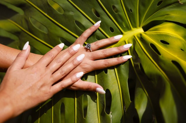 black hands with white almond-shaped nails 