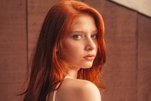woman with red hair looking at the camera