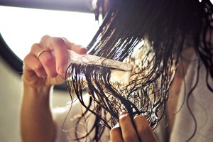 woman combing through wet hair