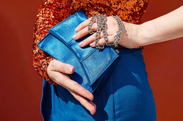 woman holding blue clutch purse