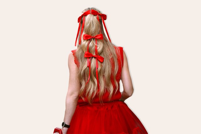 Guest is seen outside Khaite show wearing red bows in her hair, red dress