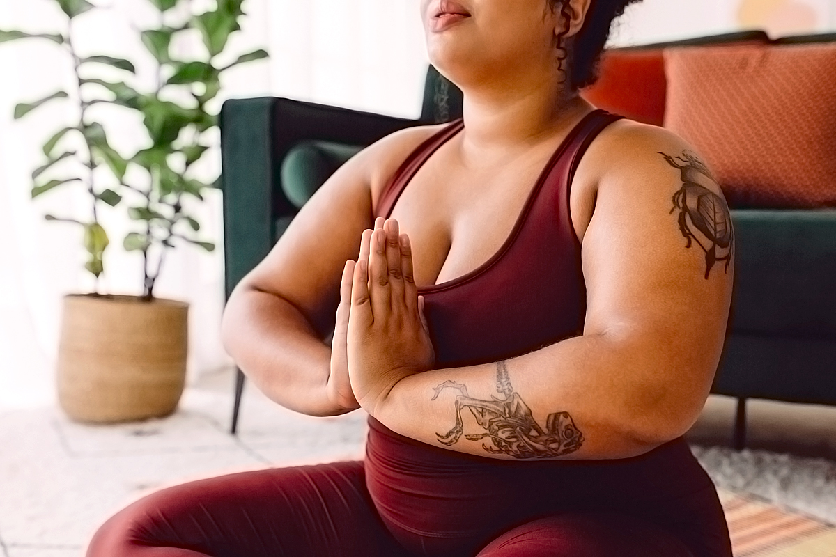 Plus size female practicing yoga meditation at home