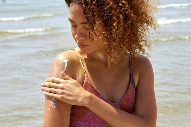 woman applying sunscreen in the ocean