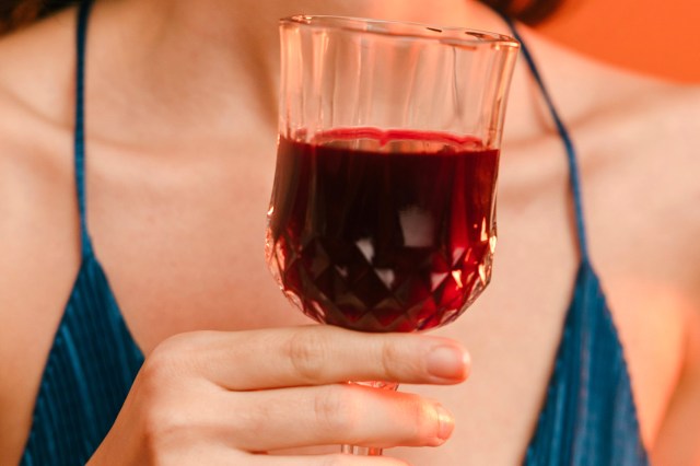 a woman holding a glass of red wine