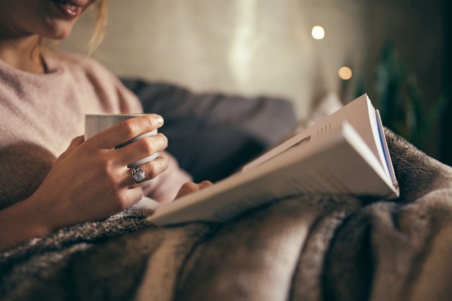 Female reading book on bed at night