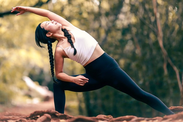woman in white tank top and black leggings doing yoga during daytime