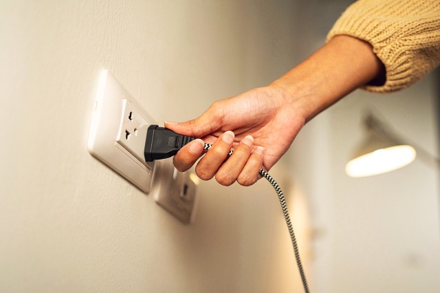 Close up woman hand put on or remove Electric plug cable in socket.