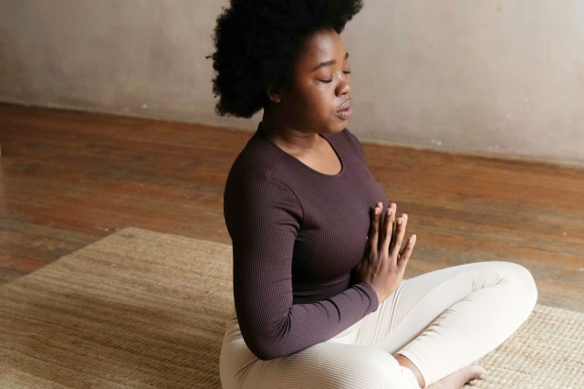 a woman sitting on the floor in a yoga pose