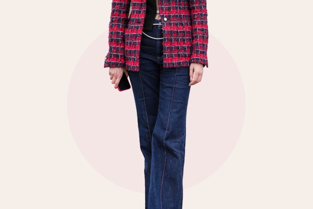 A guest wears a red and blue checkered / checked pattern printed tweed jacket with shoulder pads, a black top, blue flared denim pants / jeans,