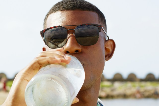 a man drinking water from a plastic bottle