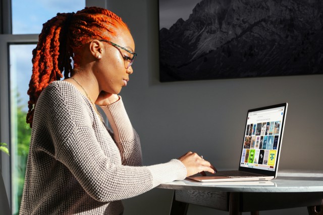 woman in gray sweater using Surface laptop