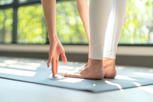 woman doing yoga stretching exercise on mat yoga & fitness exercises