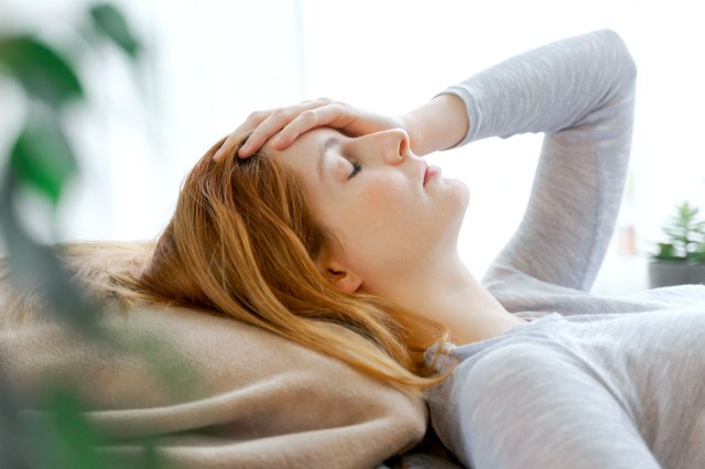 Serious young woman at home lying down