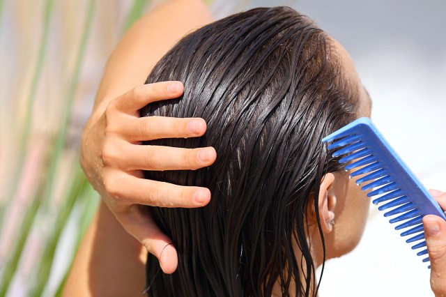 Cropped image of woman combing wet hair