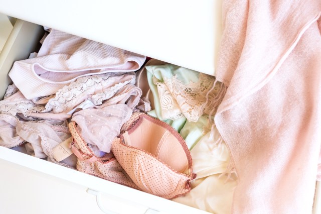 Open drawer of underwear and bras with pink scarf on right