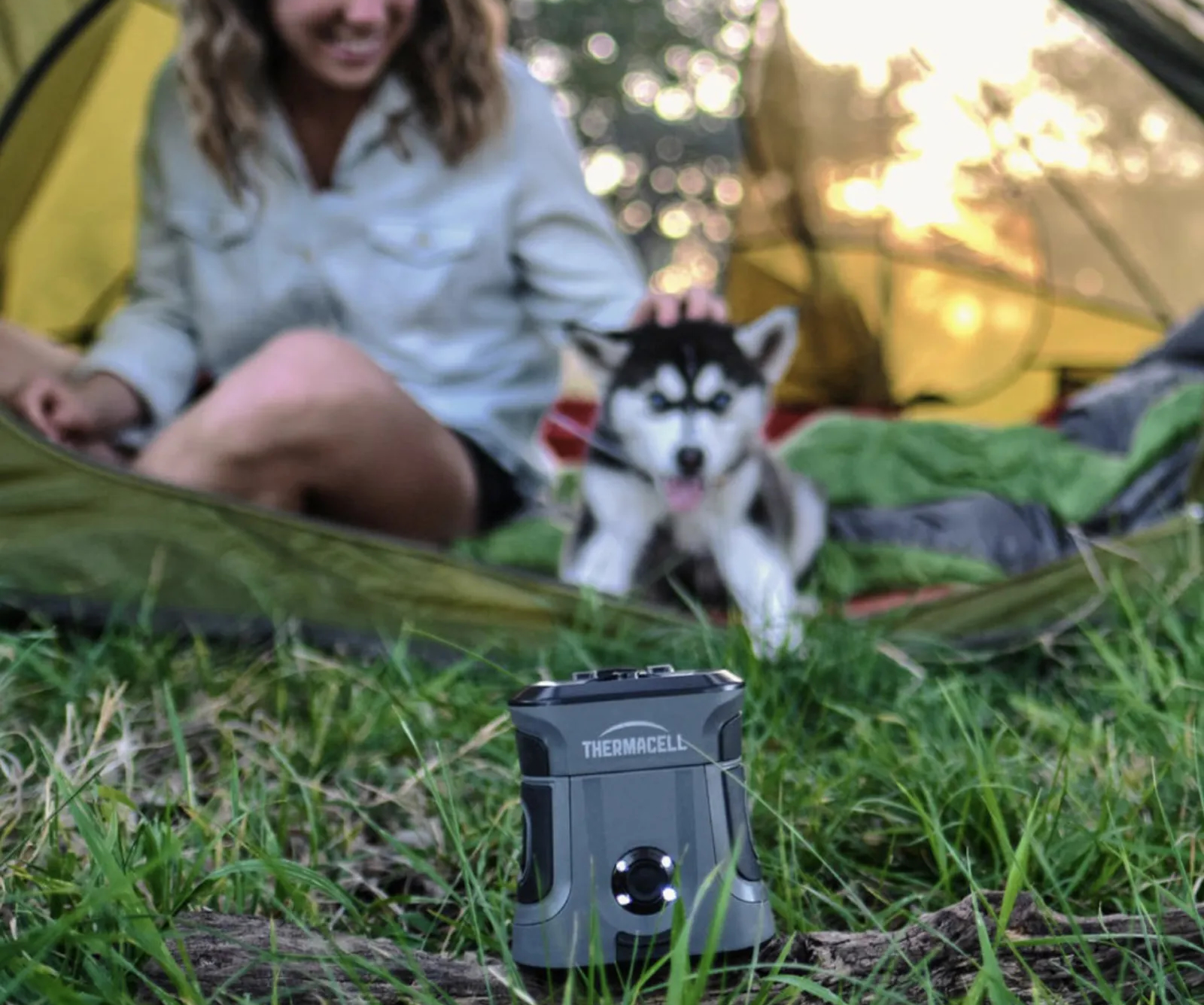 Mosquito repeller with a blurred background of woman camping with dog