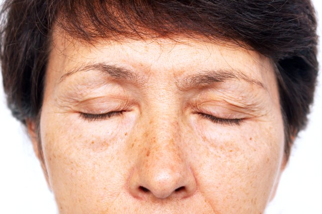 Close up of a woman with her eyes closed, puffy eyes concept