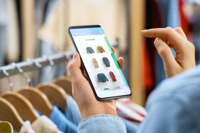 Close up of person shopping for clothes on their phone