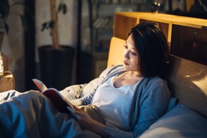 woman laying in bed reading