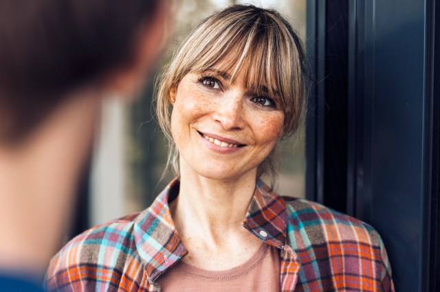 Smiling, freckled woman with bangs looking at man