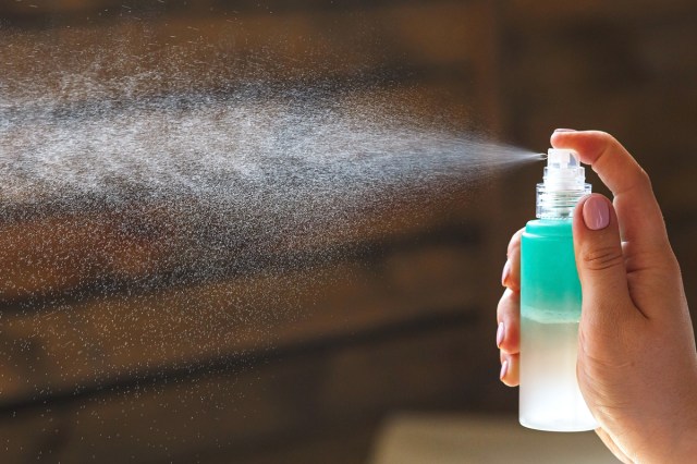 Close up of a woman's hand spraying hydrating spray
