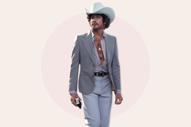 Man in grey suit, cowboy hat with many necklaces