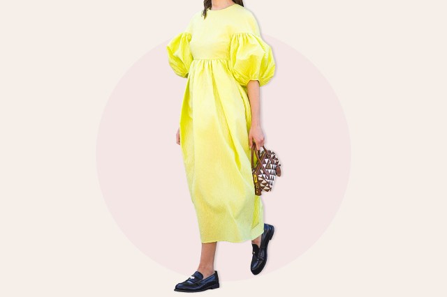 Woman wearing yellow dress with puffed sleeves and black loafers