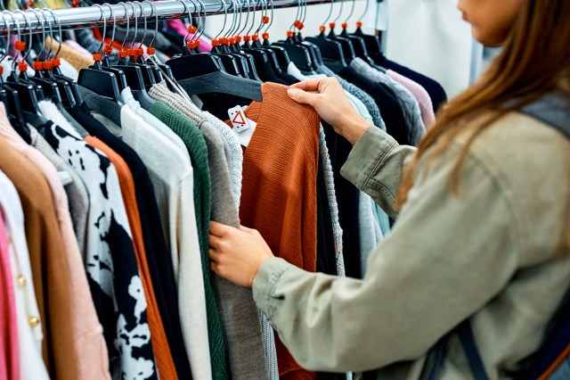 Close up of woman browsing clothing racks while shopping