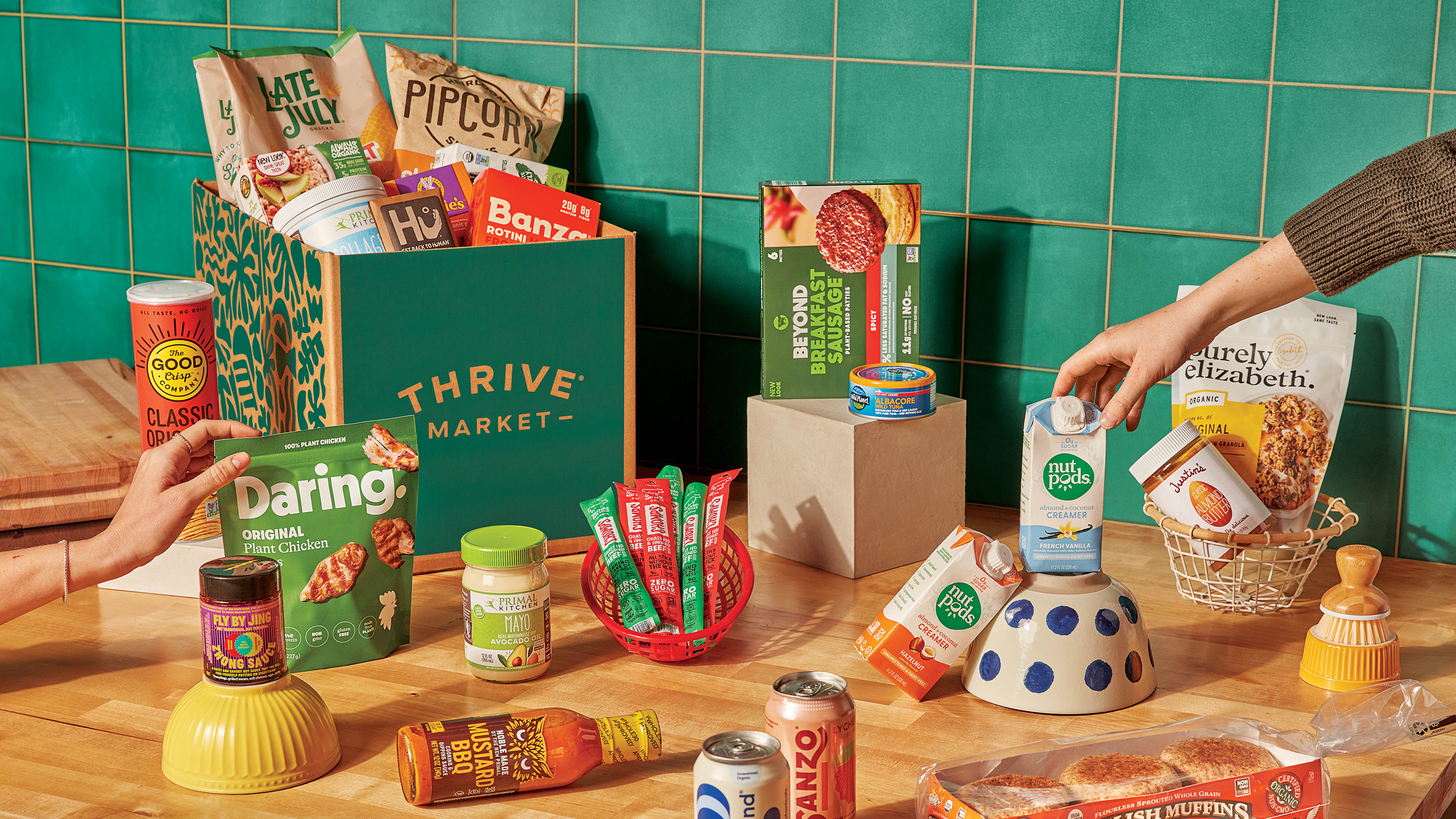 Thrive Market delivery box on table with a bunch of food and snacks laid out