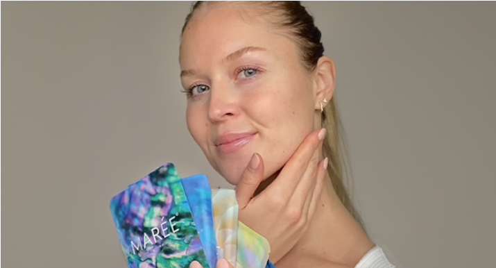 woman holding MAREE face mask packages in front of her face