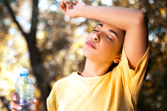 Young woman drinking water taking a break outside