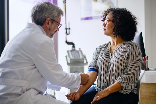 Woman getting a blood test with a doctor in office