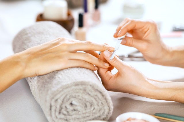 Close up of a hand getting a manicure, nails being filed
