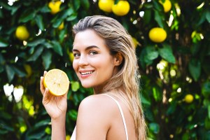 beautiful woman with a lemon fruit in her hands