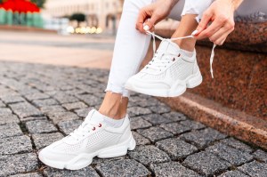 woman wearing white sneakers and white jeans