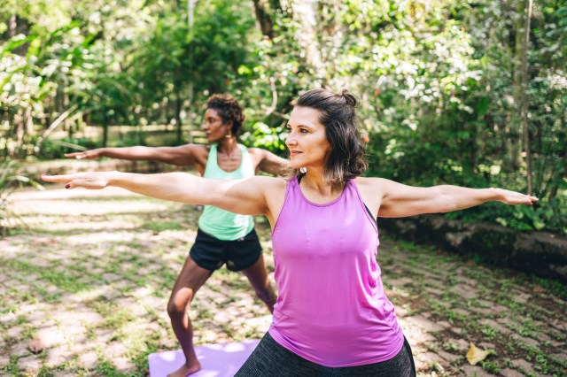 Two women doing yoga in the park