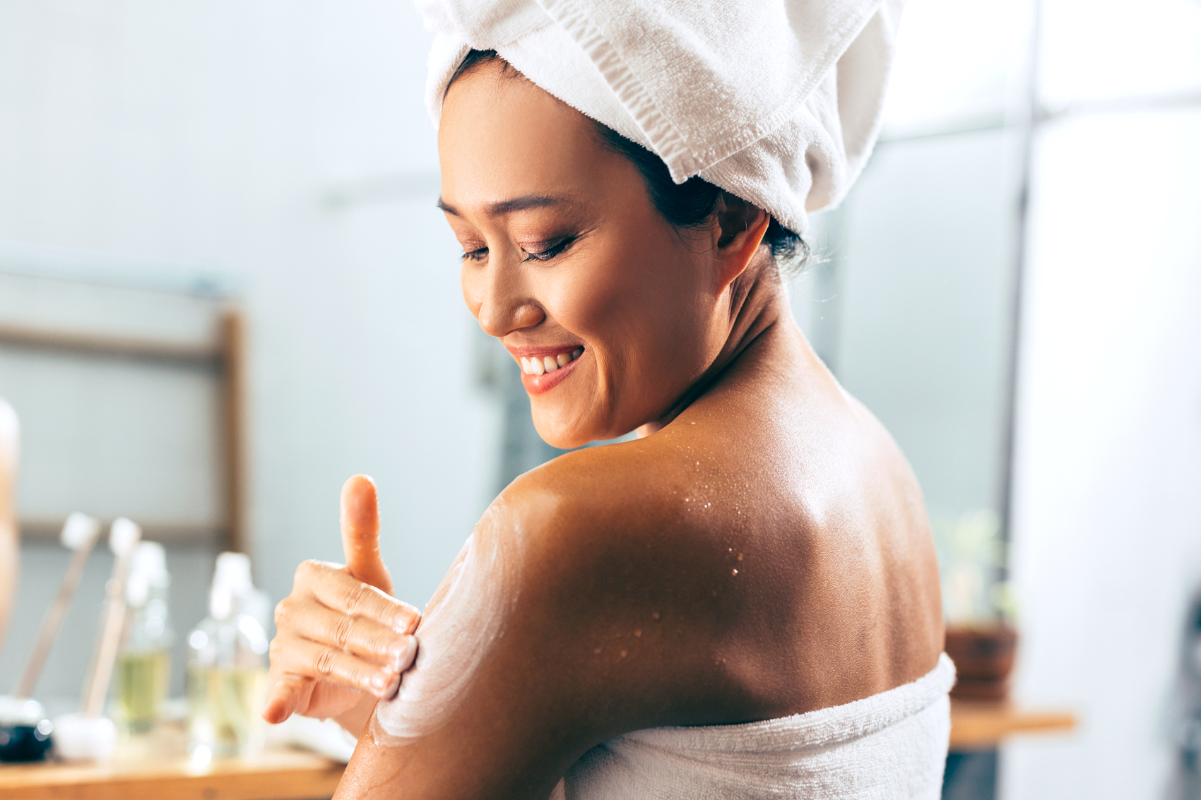 woman applying lotion on her body 