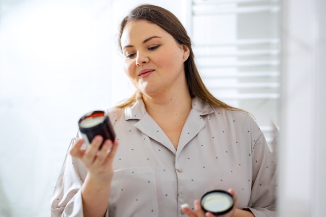 Woman Reading the Label of a Face Cream in her Bathroom