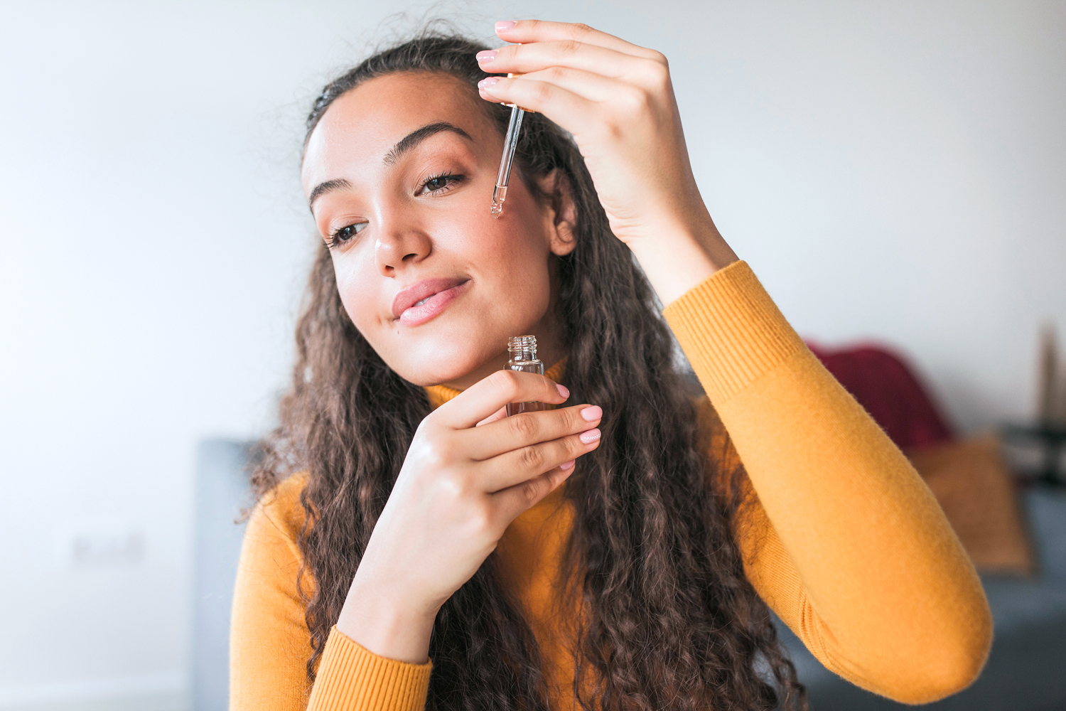 Woman applying serum to her face