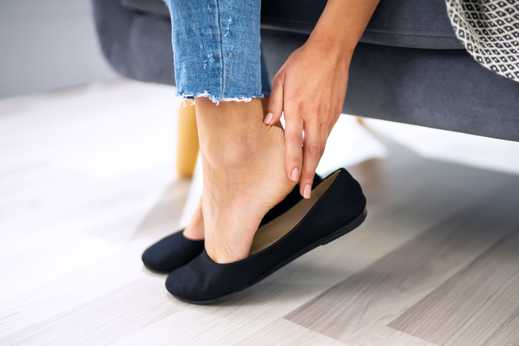 Woman's hand removing uncomfortable flat shoes