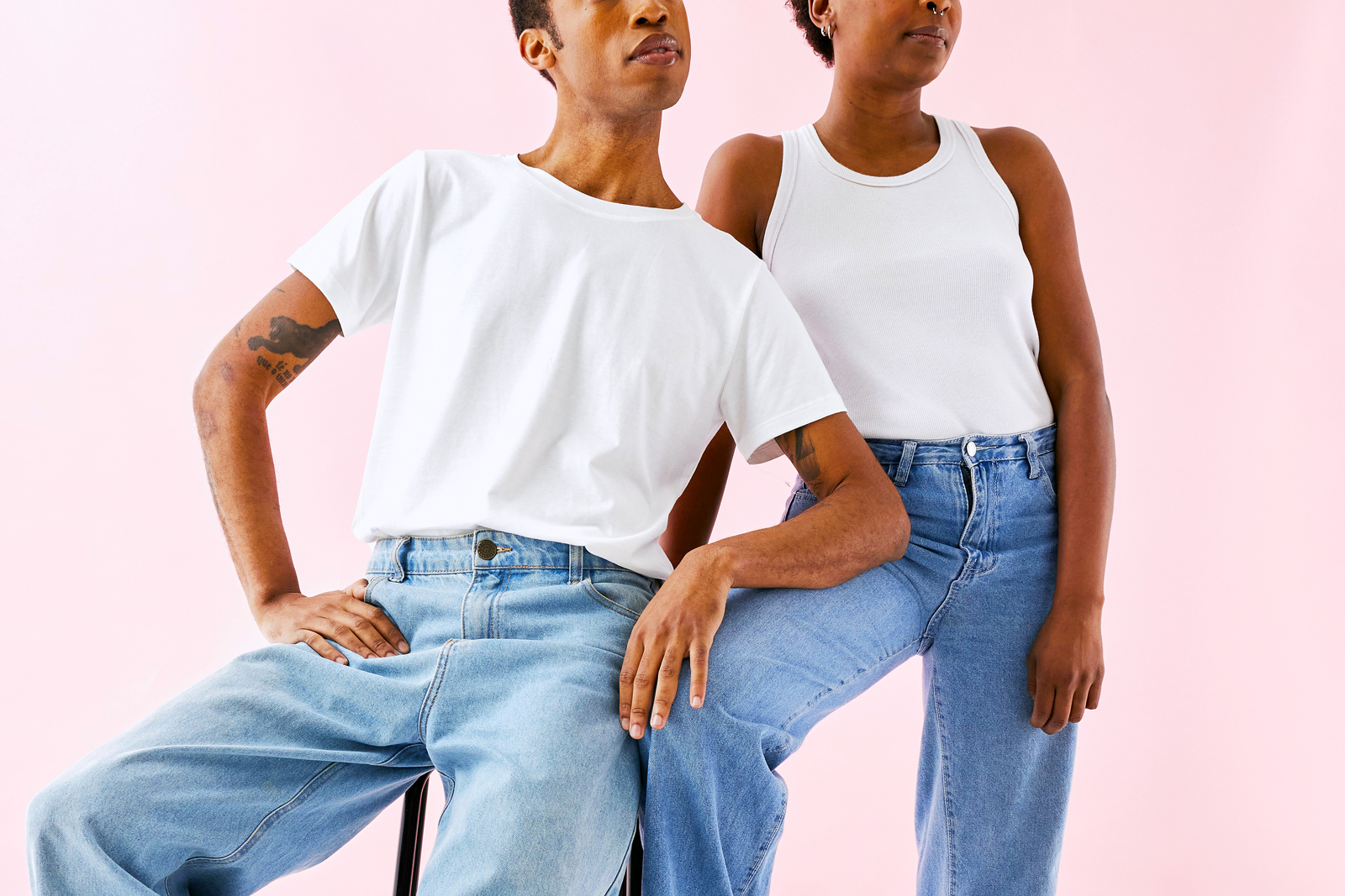 Two models wearing white shirts and jeans