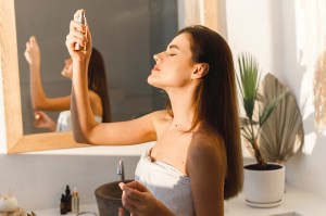 Woman spraying herself with mist