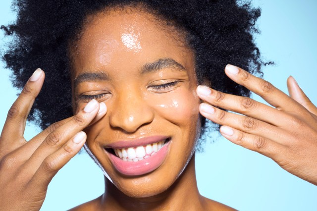 Close up of woman applying glossy cream to her face