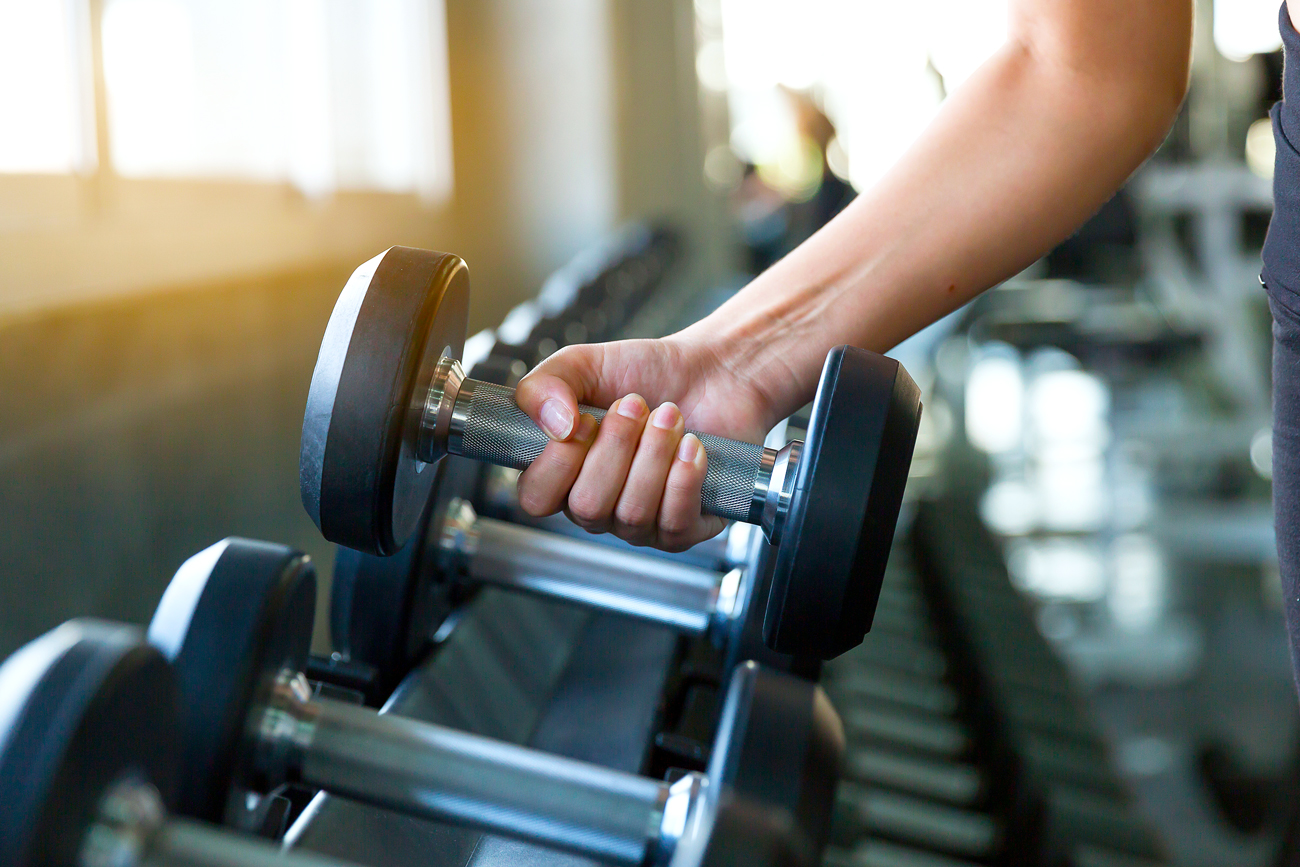 Person grabbing weight at gym