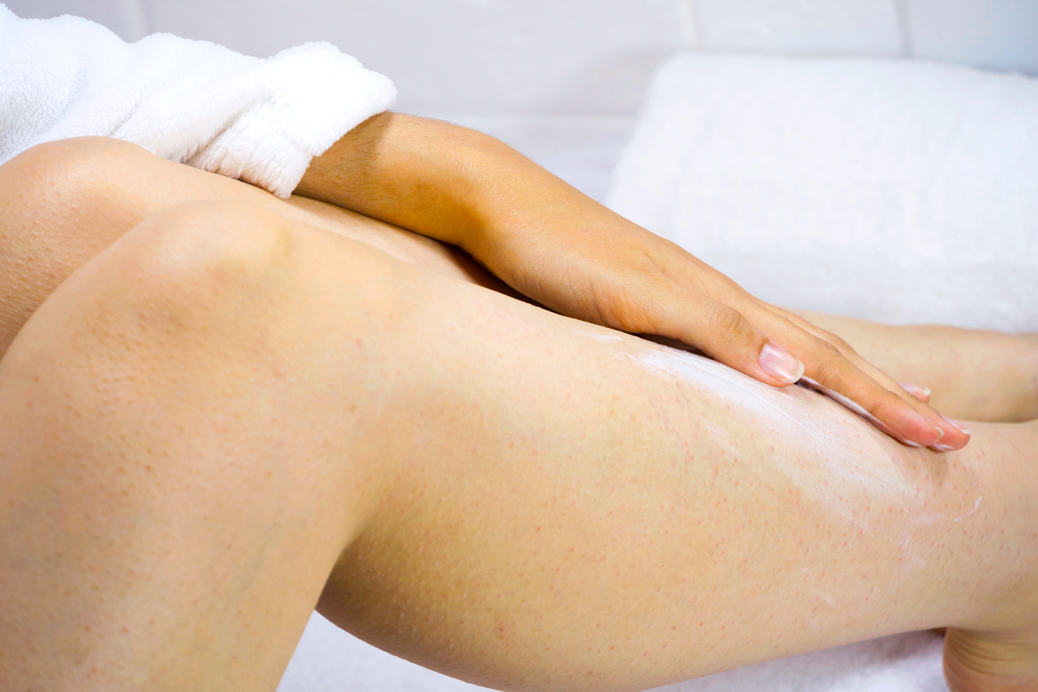 Close up of woman putting cream on her legs